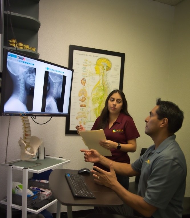 Dr. Castillo reviewing spinal X-rays with a patient at Castle Health & Wellness Chiropractic in Upland, CA